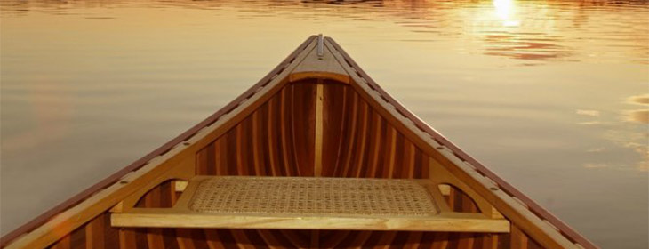 Restored vintage wooden canoe on the water